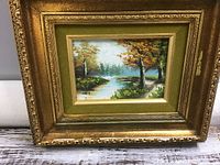 Full view of the framed original hand-painted landscape showing autumn trees and a river or stream.