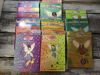 Stack of 21 Rainbow Magic books including 18 regular and 3 special editions with colorful fairy-themed covers.