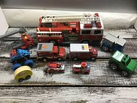 Top down view photo showing all 10 toy trucks arranged on a wooden surface.