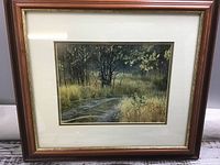 Front view photograph of the framed artwork showing the woodland path with a fox and the frame details.