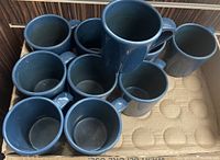 Top view photo showing all ten blue lapis mugs stacked and arranged inside a box, displaying their uniform color and shape.