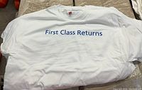 Front view of one white Hanes t-shirt displaying blue "First Class Returns" text across the chest.