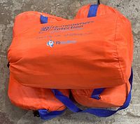 Orange bags with blue handles, branded with Homeowners Protection and Fb Systems logos, folded and placed together in a pile