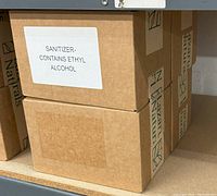 Closed cardboard boxes with Lazarus Naturals branding and label stating sanitizer contains ethyl alcohol