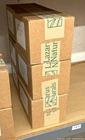 Closed stacked cardboard cases labeled Lazarus Naturals, containing hand sanitizer.