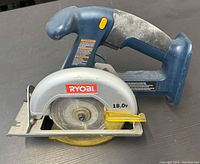 Front view of blue and gray Ryobi cordless circular saw showing 18V label and 5.5 inch blade with yellow guard.