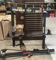 Front view of the Yakima bike rack with stickers and mounted attachments, showing full rack structure and parts on concrete floor.