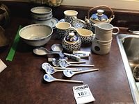 Full view of the set on a wooden surface including teapot, cups, saucers, bowls, and other ceramic pieces