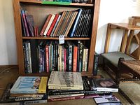 Full view of bookshelf with books arranged, showing a large assortment of coffee table and reference books about history, travel, nature, and culture.