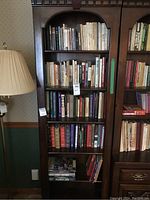 Front view of six-shelf dark wood bookcase loaded with books