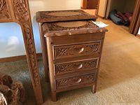 Full side view of the larger nesting table with drawers and part of the smaller table nested underneath.