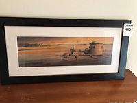 Full view of framed watercolour painting showing the waterfront, boats, and Martello tower with MaxSold sticker visible.