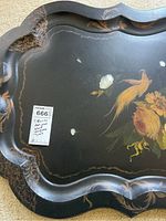 Antique black lacquered tray showing scalloped edges, gold detailing, and hand-painted bird and flowers with visible wear and small chips.