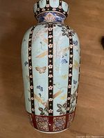 Full-height view of vase body showing turquoise panels, black bands with cherry blossom motifs and gold butterflies