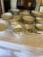 Collection of decorative N.Z Austria Kaiserin Maria Theresia Carlsbad China including plates, bowls, gravy bowl, gravy pitcher, and covered food container all with floral and gold trim.