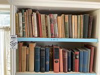 Books on shelves, showing full spines and titles, vintage collection of poetry, literature, and mythology books.