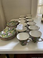Cups and saucers arranged on table showing multiple floral-patterned cups and matching saucers
