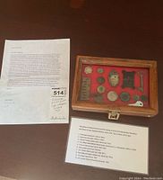 Wide shot of the historical items with description papers beside the wooden display case