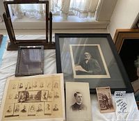 Overview of lot items including framed photos, group collage, individual portraits, and empty wooden frame stand.