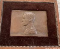 Front view of framed plaque showing the relief bust and velvet matte under glass.