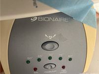 Close-up photo of the Bionaire tower fan control panel showing the temperature settings from 60 to 80 degrees and power mode buttons.
