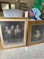 Overall view of three large vintage framed photos leaning against a chair and table, showing size and framing details.