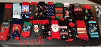 20 pairs of Christmas socks laid out in rows, showing a wide variety of festive holiday patterns and characters.