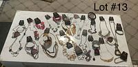 Full lot of 42 pieces including necklaces, matching earring sets, and bracelets displayed on white surface.