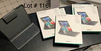 Five Logitech Slim Folio Pro keyboard folio cases for iPad Pro 12.9 3rd generation, four still in boxes, one open showing keyboard and case interior.