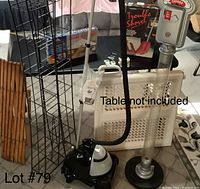 Metal CD rack, baby gates, vintage snow shovel in box, clothes steamer, parking meter band, and wooden slatted item all together on floor