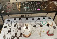 Photo of 30 Paparazzi jewelry sets including necklaces and matching earrings displayed on two tables, variety of styles and colors