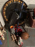 Photo showing a mini trampoline, basketball, rugby ball, foam roller, massage rollers, black exercise step, and padded exercise equipment.