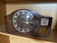 Full view of original Junghans mantel clock with wood casing and round face.