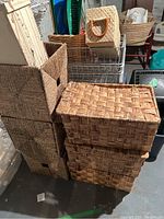 Wicker baskets in stackable sets with different sizes and weaving styles shown on concrete floor