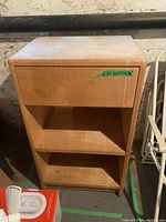 Front view of wood cabinet showing one drawer and two open shelves