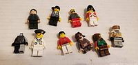 Photo of 10 assorted vintage LEGO minifigures laid out on a white surface.