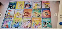 Top view of 15 Little Golden Books arranged in three rows showing colorful illustrated covers of classic children's characters and learning stories.