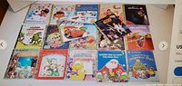 Photo of the front cover face of all 17 Little Golden Books arranged in two rows showing titles from 1990s and later, including Disney and classic children's themes.
