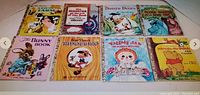 Eight classic Little Golden Books arranged on the floor showing their colorful front covers with titles and popular children's characters.