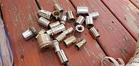 Multiple assorted sockets laid out on a wooden surface; shows variety of socket sizes and designs, chrome finish visible.