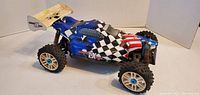 Side view of OFNA Ultra GT LX Nitro Buggy RC Car showing body details and tires.