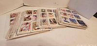 Several clear page sleeves with white bordered baseball cards arranged on a flat surface.