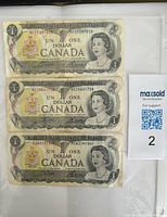 Three Canadian 1973 one dollar banknotes Series B showing front side with Queen Elizabeth II portrait and serial numbers.