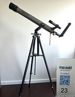 Full view of silver Magnicon telescope on black tripod with equatorial mount and finder scope