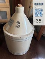 Front and side view of the Medalta pottery jug with conical spout and cork stopper, showing the number '3' on its front.