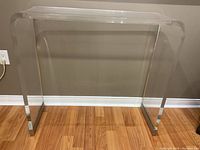 Front view of clear acrylic table showing transparent design and rounded edges.