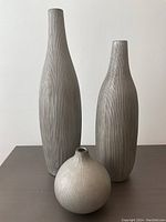 Front view of all three ceramic vases showing varying heights and ribbed texture.