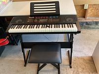 Front view of the Rock Jam keyboard on stand with bench showing overall condition and setup.