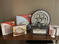 Full display of Jewish Seder Passover items including Seder plate, matzah boxes, napkin holder, foie gras service, and goblet on wooden surface