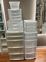 Front view of the stacked plastic drawer units showing clear and white plastic drawers in various sizes and designs.